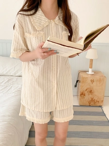 Detail of cream short-sleeve pajama set with black polka dots and fringe trim details
