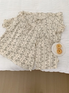 Flat lay of floral pajama set featuring tie-neck top and matching lounge pants