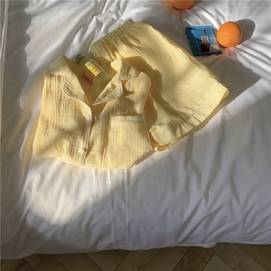 Detail of yellow double gauze cotton pajamas featuring white piping and textured fabric