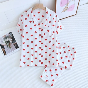 Détail d'un pyjama en coton blanc avec imprimé cœurs et chemise boutonnée à revers