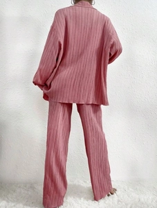 Detail of dusty pink pleated two-piece set featuring elegant texture and loose silhouette