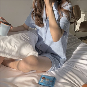 Detail of light blue short-sleeved pajama set with white piping on cotton crepe fabric