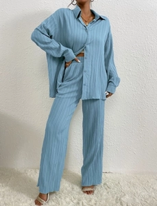 Close-up of light blue plisse fabric texture on a long sleeve shirt and wide leg pants set