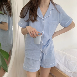 Close-up of light blue cotton gauze pajamas featuring short sleeves and white piping details