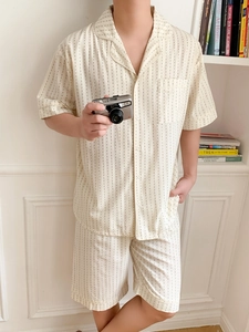 Detail view of men's beige short-sleeve pajama set with fine vertical black dot stripes