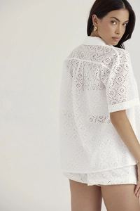 Detail of white eyelet embroidery on women's short sleeve shirt and shorts set