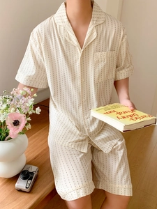 Detail view of men's cream striped pajamas with short-sleeved button-down shirt and shorts