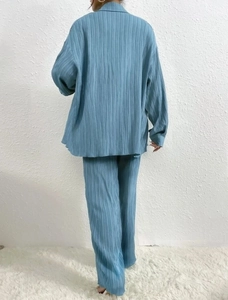 Detail showing the light blue pleated texture and fluid drape of the two-piece lounge set