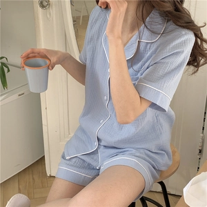 Detailed view of light blue seersucker pajamas set with white contrast piping trim