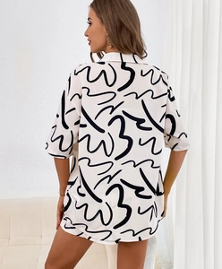 Detail of the back view on a white short-sleeve shirt with black abstract art patterns
