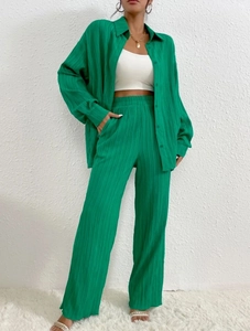 Detail of emerald green pleated fabric on casual long sleeve shirt and wide leg pants