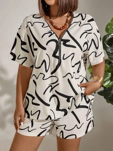 Close-up of short sleeve top with zipper neckline and abstract graffiti print fabric