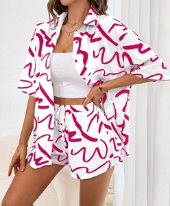 Close-up of women's floral two-piece summer set with pink patterns on white fabric
