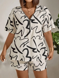 Detail of V-neck short sleeve top with metal zipper and abstract line print shorts