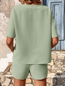 Détail du tissu gaufré vert sauge sur l'ensemble de détente t-shirt ample et short