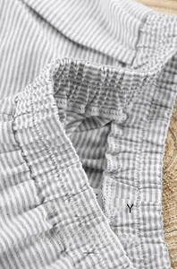 Détail de la taille élastique et des coutures d'un short de pyjama en tricot rayé