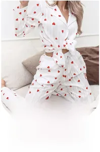 Detail of white cotton pajamas set with red heart print and button-down shirt texture