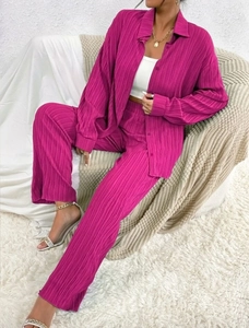 Detailed texture of vibrant pink pleated long-sleeve shirt and matching trousers set