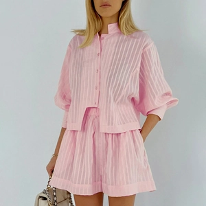 Detailed texture of pink striped button-down shirt and matching elastic shorts set