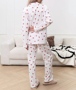 Detail of white cotton pajamas featuring red heart prints and vertical ribbed texture