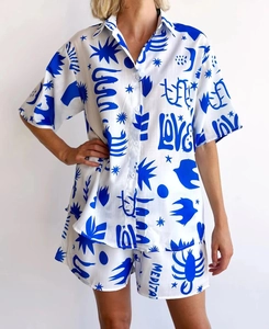 Detail of artistic lobster and palm tree prints on short sleeve shirt and shorts set