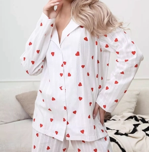Detail of red heart prints on white long-sleeve cotton pajamas with button lapel