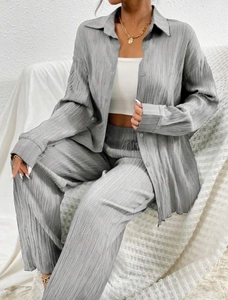 Close-up of gray pleated fabric texture on a loose long-sleeve shirt and matching pants