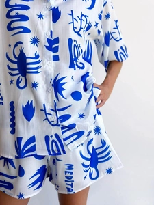 Detailed view of lightweight white fabric with blue Medita print on shorts and shirt