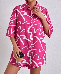 Close-up of pink printed short-sleeve shirt with lapel and white abstract patterns