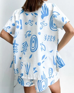 Back view of a white and blue artistic floral print pajama set with shorts and top