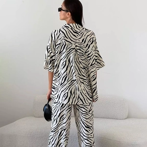 Dettaglio completo di set in raso con stampa zebrata composto da camicia e pantaloni vita alta