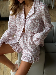 Detailed close-up of pink leopard print pajama set featuring ruffle hem shorts and buttons