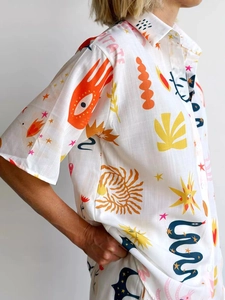 Close-up of the textured fabric and artistic sun and palm prints on the white shirt