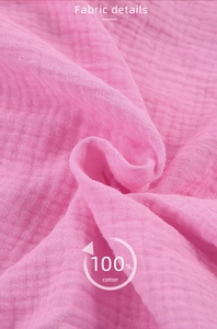 Detailed macro view of pink 100% cotton crepe fabric showing soft wrinkled texture