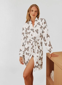Detail of white knit robe featuring pink butterfly prints and silk-like fabric texture