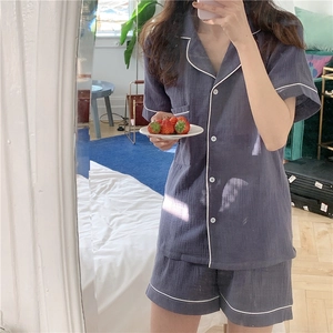 Detail of grey-blue gauze pajama set with white piping and breast pocket texture