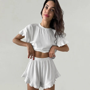 Détail de la matière côtelée blanche et des bords à volants sur l'ensemble homewear