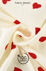Vue détaillée du tissu en double gaze 100% coton avec motifs de cœurs rouges