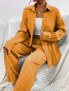 Close-up of the pleated texture and flowing fabric on the yellow two-piece lounge set