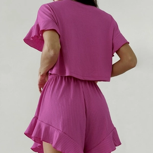 Détail de l'ensemble de détente rose côtelé avec bords à volants sur manches et short