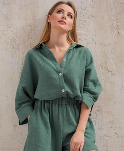 Detail view of dark green crepe fabric texture on long sleeve shirt and shorts set
