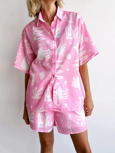 Detail of pink two-piece short set with abstract white prints and resort style fabric