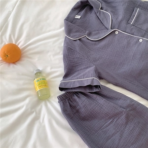 Detail of purple-gray gauze cotton pajamas set with white piping and button closure