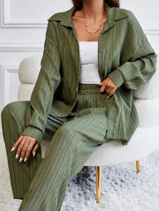 Detailed texture of olive green pleated fabric on casual shirt and wide-leg trousers
