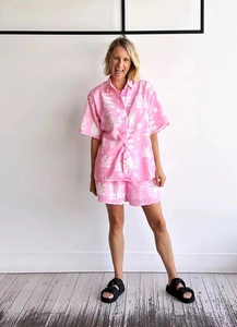 Detail of pink short-sleeve shirt and shorts set with white graphic and letter prints