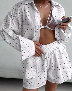Detail eines Baumwoll-Schlafanzugsets mit Herzmuster und weißem Spitzen-Bralette