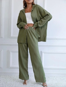 Detailed texture of olive green pleated fabric on oversized button shirt and wide-leg pants