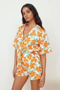 Dettaglio del set bianco a due pezzi con vivace stampa floreale arancione e camicia con revers