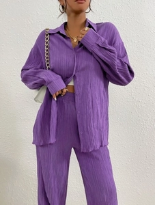 Detail shot of the vertical pleated texture on this purple two-piece long sleeve shirt and pants