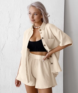 Detailed macro view of cream crepe cotton fabric texture and brown buttons on loungewear